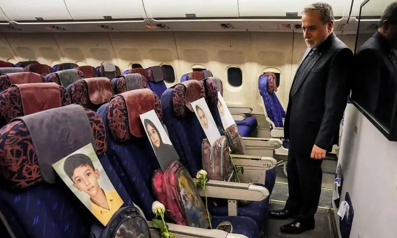 Iranian Foreign Minister Abbas Araghchi looks at damaged bags and shoes placed in an airplane cabin, along with pictures of four children from Minab, according to a social media post, in this handout image taken at an unknown location and released on April 11, 2026. — Abbas Araghchi via Telegram via Reuters