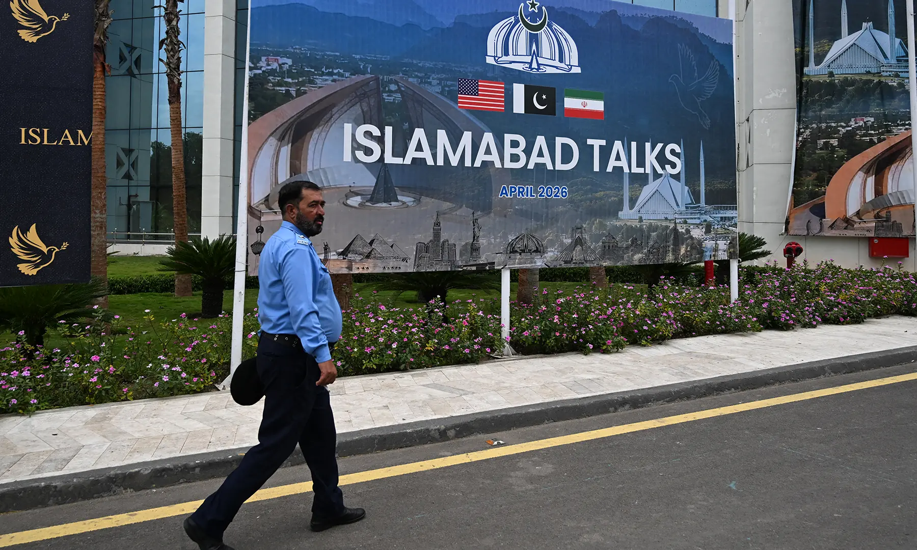 A police officer walks past a billboard for the US–Iran peace talks in Islamabad on April 11, 2026. — AFP A police officer walks past a billboard for the US–Iran peace talks in Islamabad on April 11, 2026. — AFP