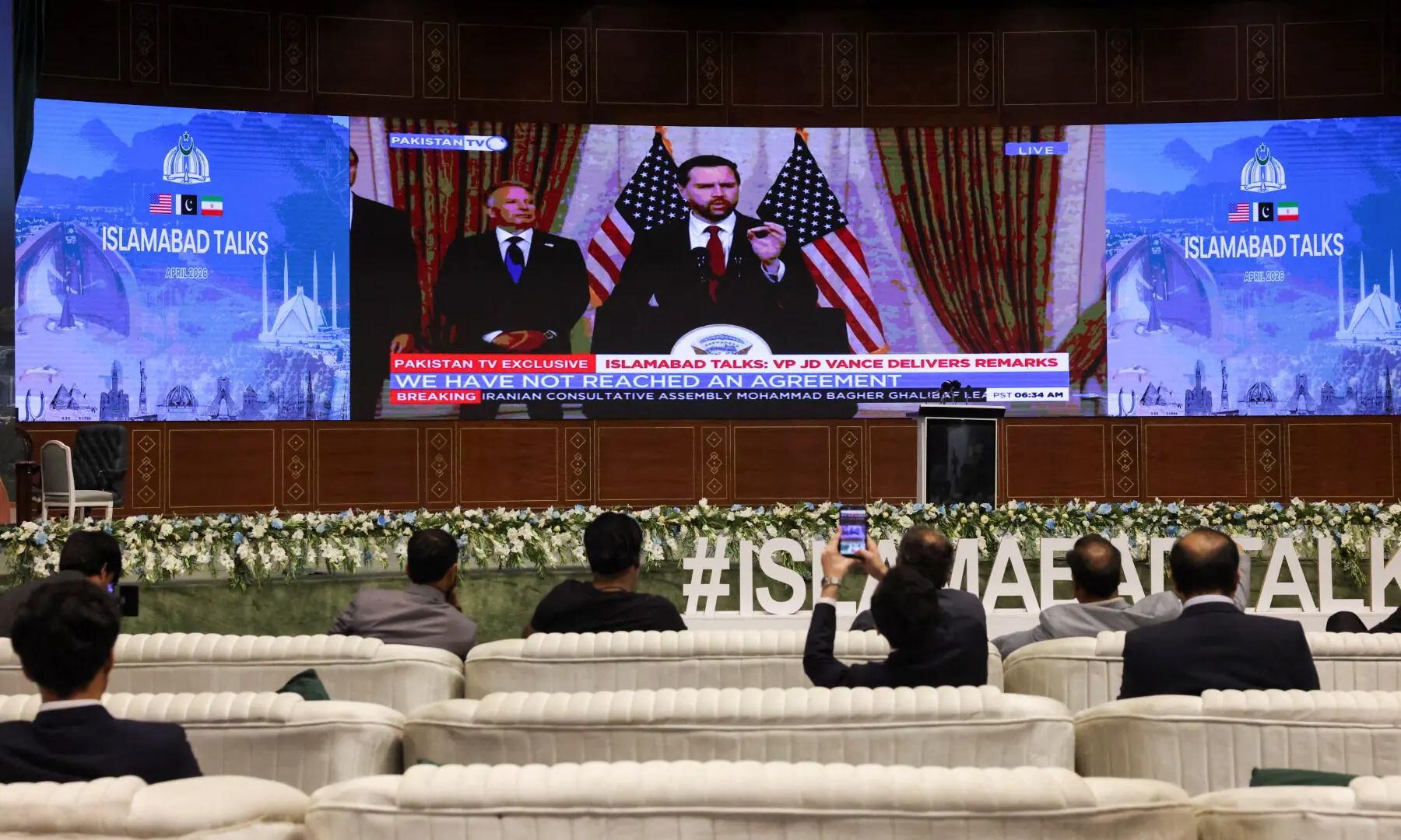 A screen displays US Vice President JD Vance addressing a press briefing in Islamabad on April 12, 2026. &mdash; Reuters