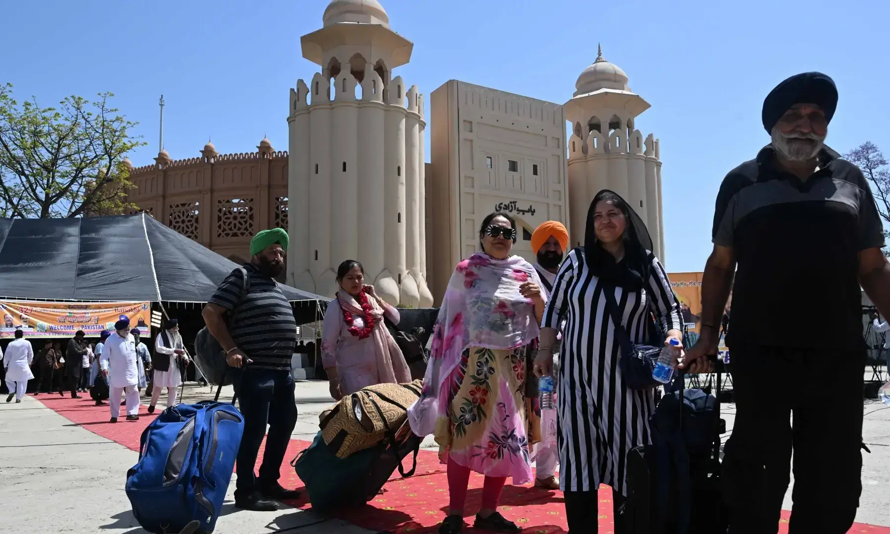 Sikh pilgrims carry their luggage as they arrive in Pakistan from India via Wagah border on April 10, 2026. &mdash; White Star/ Arif Ali
