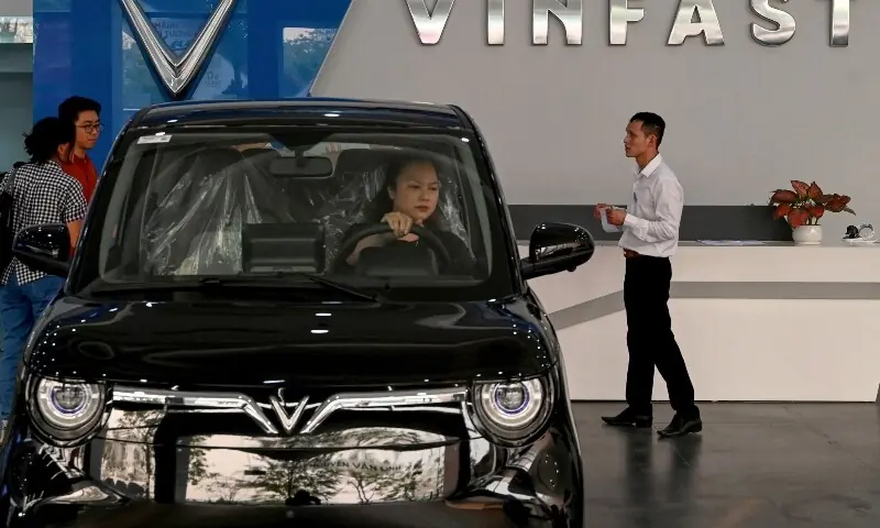 This photo taken on April 11, 2026, shows a woman behind the wheel of a car inside a VinFast electric car dealership in Hanoi. &mdash;AFP
