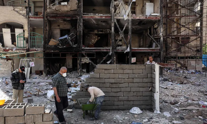 Workers build up a structure in front of a residential building hit by US-Israel airstrikes days before a two-week ceasefire between Iran and the United States took effect, at the Shahid Broujerdi residential complex in southern Tehran on April 14, 2026. &mdash; AFP