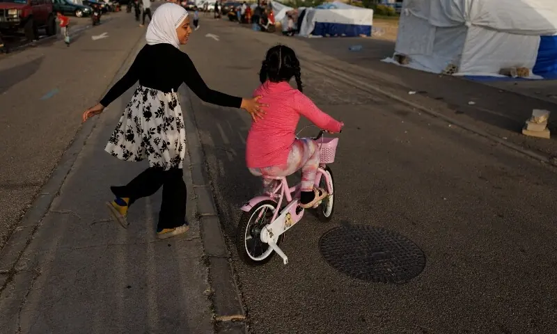 Girls displaced following Israeli evacuation orders ride a scooter at a makeshift encampment in Beirut, Lebanon, April 15, 2026. &mdash;Reuters