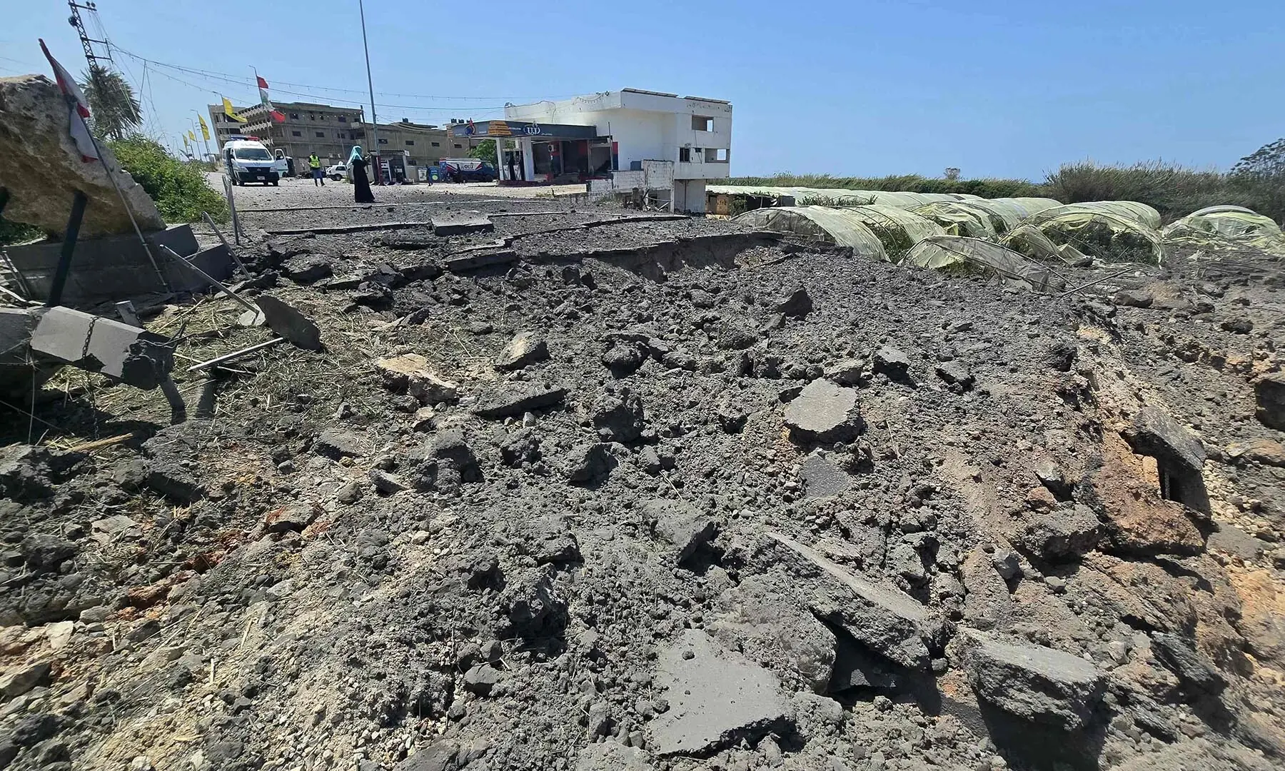 A woman takes pictures of the site of Israeli strikes that targeted the Qasmieh bridge, built over the Litani River, in the southern Lebanese area of Al Qasmiyeh on April 16, 2026. &mdash; AFP