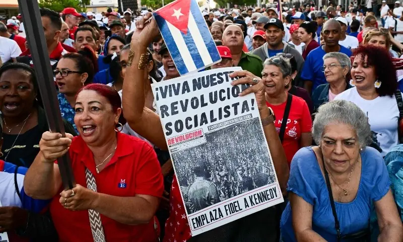 A woman holds a poster reading &ldquo;Long live our socialist revolution&rdquo; during celebrations marking the victory on the 65th anniversary of the Bay of Pigs invasion and the declaration of the socialist character of the Cuban Revolution in Havana on April 16, 2026. &mdash;AFP