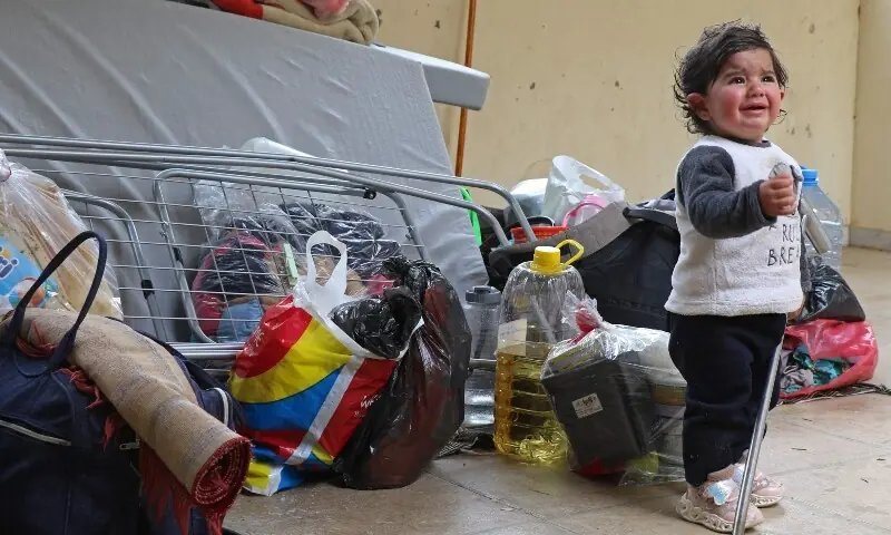 A child stands next to the belongings of his displaced family in a school transformed into a shelter in the central Lebanese village of Deir Al-Ahmar on April 17, 2026. &mdash;AFP