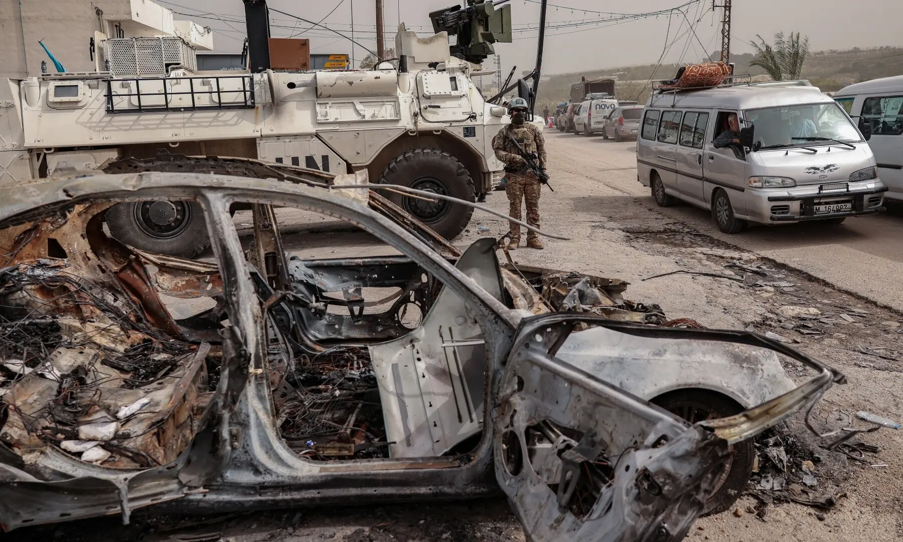A member of UN peacekeeper stands by a burned out car, as displaced people make their way back to their homes after crossing the bridge linking southern Lebanon to the rest of the country, following the ceasefire between Lebanon and Israel in Qasmiyeh, Lebanon on April 18, 2026. &mdash;Reuters