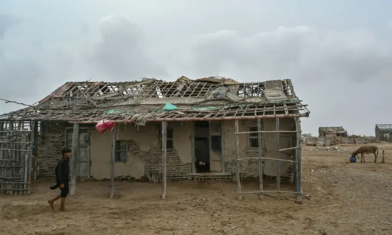 This August 2025 photo shows a boy walking past an abandoned house in one of the villages of Kharochhaan, which once comprised about 40 villages &mdash; most now lie underwater and several have been abandoned | AFP