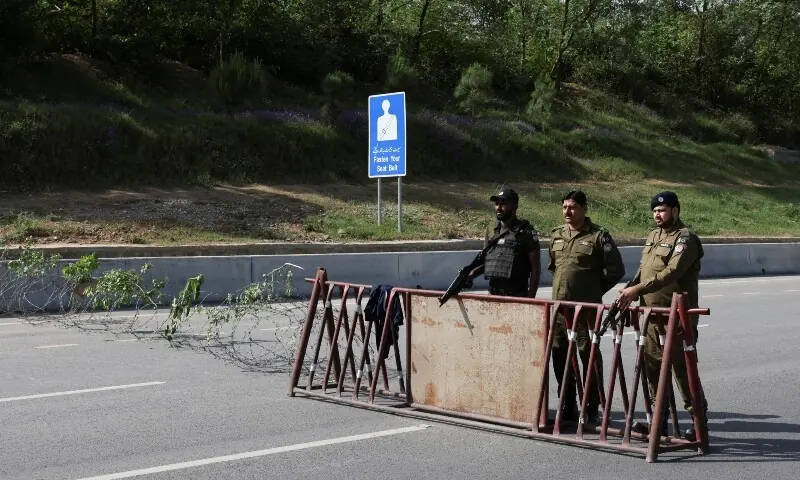 Police officers stand at a security checkpoint along a road, as Pakistan prepares to host the US and Iran for the second phase of peace talks in Islamabad, April 19. &mdash; Reuters