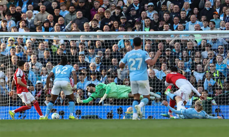 MANCHESTER: Erling Haaland (front R) of Manchester City scores past Arsenal goalkeeper David Raya during their Premier League match at the Etihad Stadium on Sunday.
&mdash;AFP