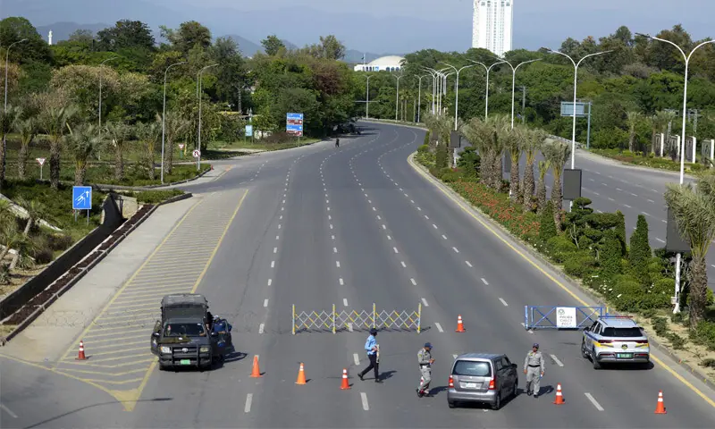 POLICE personnel stop motorists from proceeding towards the high-security Red Zone at a picket on Islamabad’s Club Road.—Mohammad Asim / White Star POLICE personnel stop motorists from proceeding towards the high-security Red Zone at a picket on Islamabad’s Club Road.—Mohammad Asim / White Star