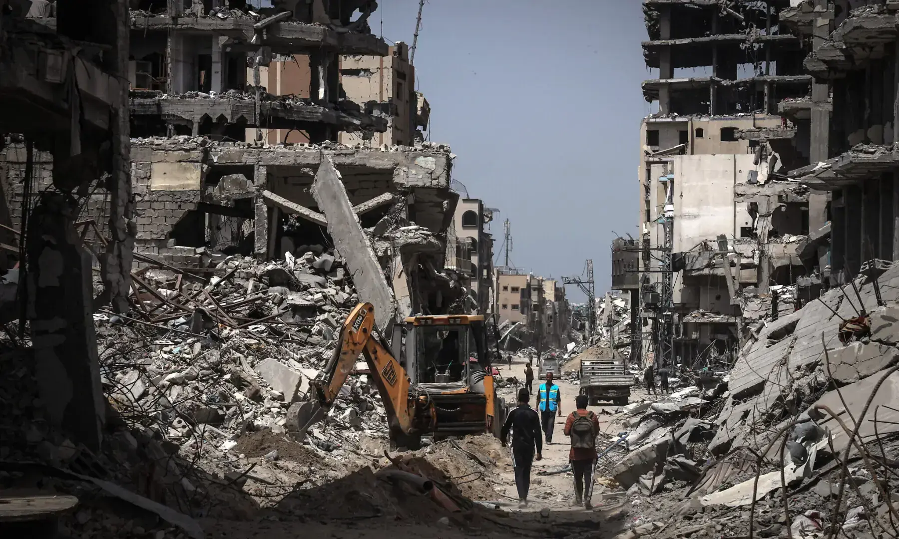 People walk on a road lined with destroyed buildings in Khan Younis in the southern Gaza Strip on April 23, 2024. &mdash; AFP/File