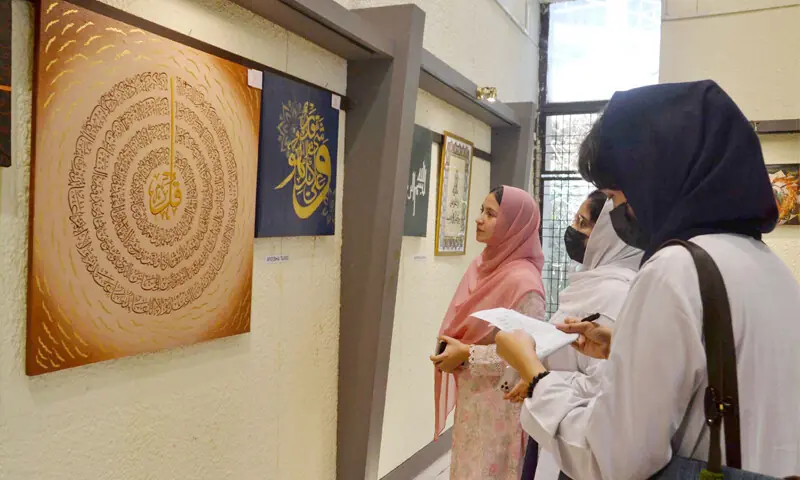 Visitors take interest in a piece of artwork displayed at a literary festival in Nishtar Hall, Peshawar, on Monday. — White Star Visitors take interest in a piece of artwork displayed at a literary festival in Nishtar Hall, Peshawar, on Monday. — White Star