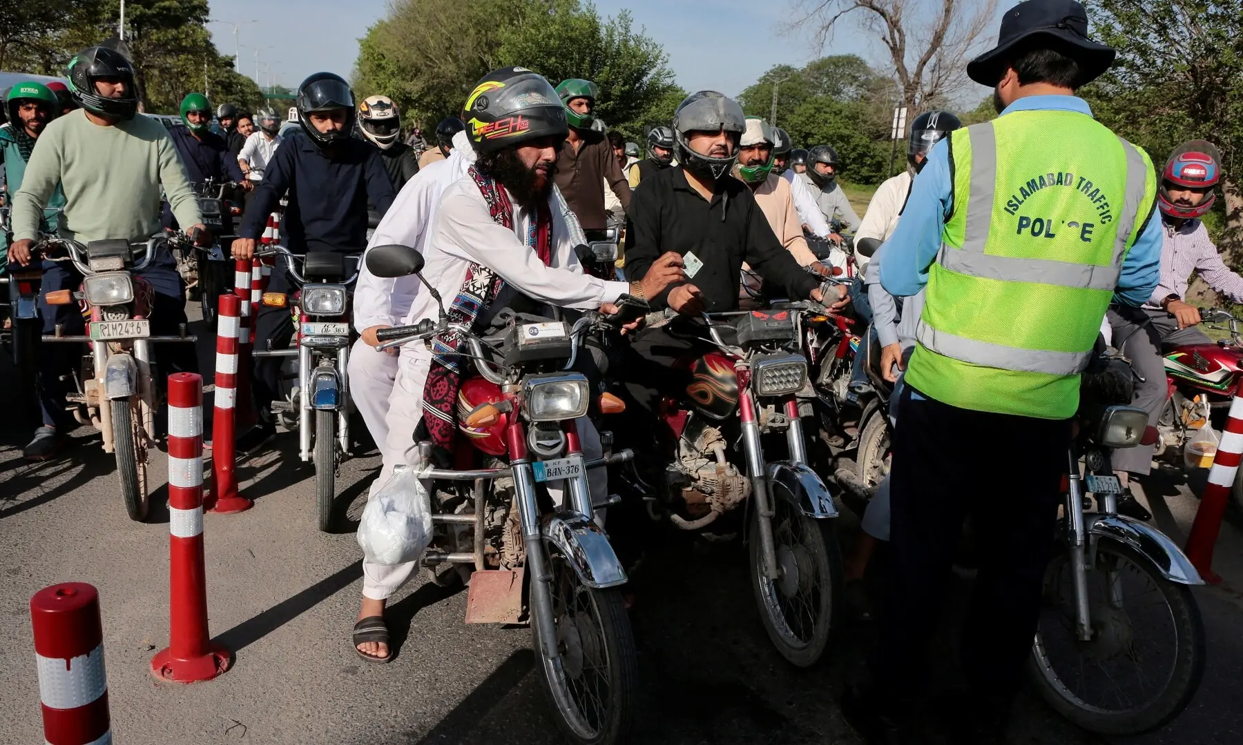 A police officer checks the identity papers of commuters at a checkpoint in Islamabad on April 21, 2026, as Pakistan prepares to host the US and Iran for a possible second round of peace talks. &mdash; Reuters