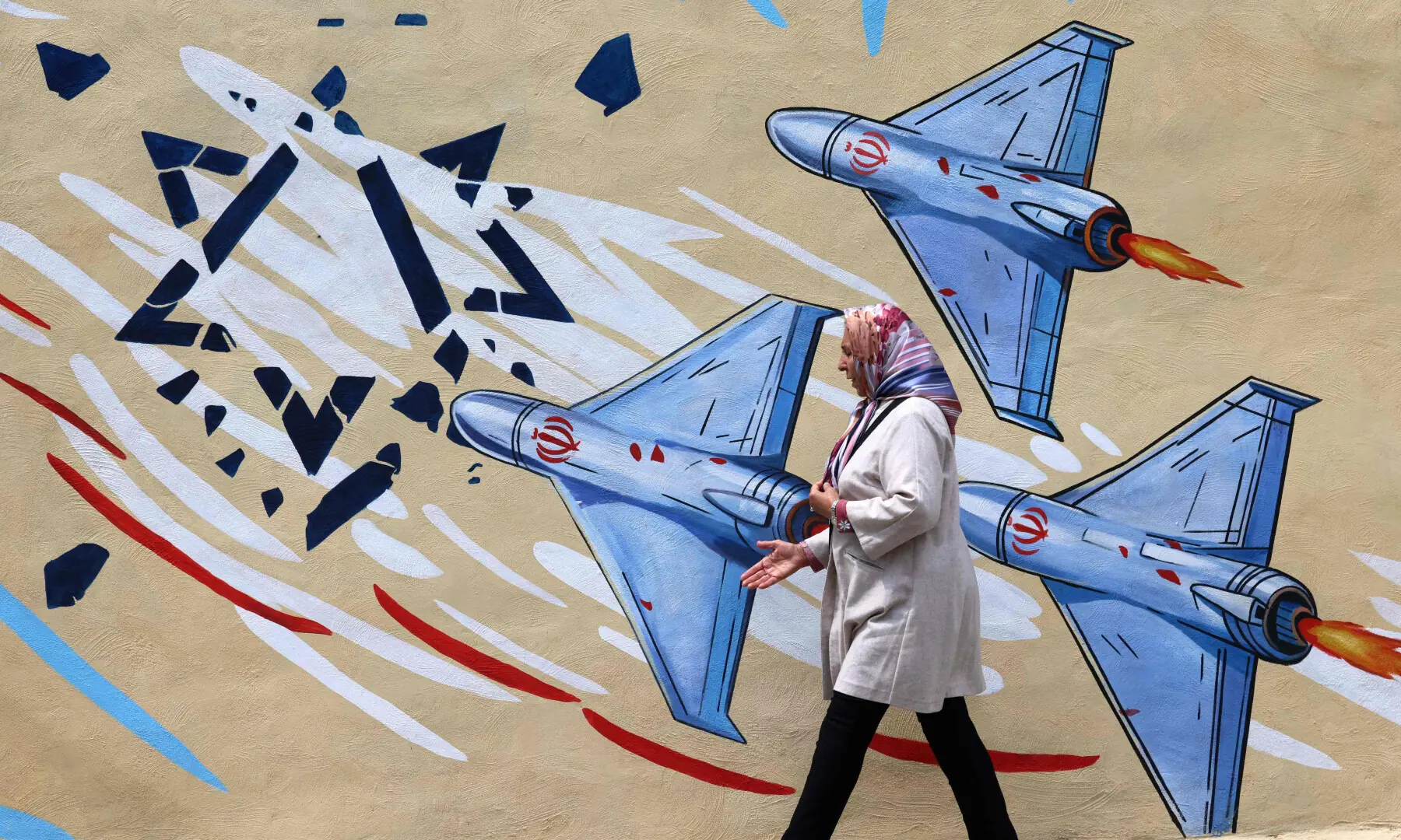 This photo taken on April 8, 2026 shows a woman walking past an anti-USA and anti-Israel mural, in Tehran. — AFP/File This photo taken on April 8, 2026 shows a woman walking past an anti-USA and anti-Israel mural, in Tehran. — AFP/File