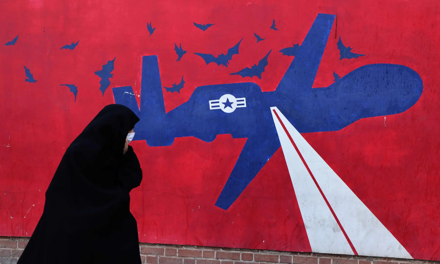 This photo taken on Feb 1, 2026 shows a woman walking past a mural depicting a US drone painted on the outer walls of the former US embassy in Tehran, colloquially-referred to as the &ldquo;Spy Den&rdquo;. &mdash; AFP/File