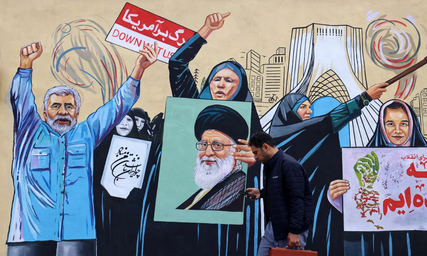 This photo taken on April 8, 2026 shows a man walking past an anti-USA and anti-Israel mural, in Tehran. &mdash; AFP/File