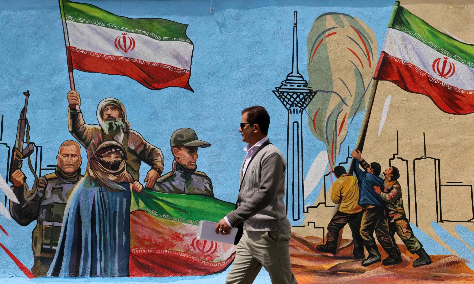 This photo taken on April 8, 2026 shows a man walking past an anti-USA and anti-Israel mural, in Tehran. &mdash; AFP/File