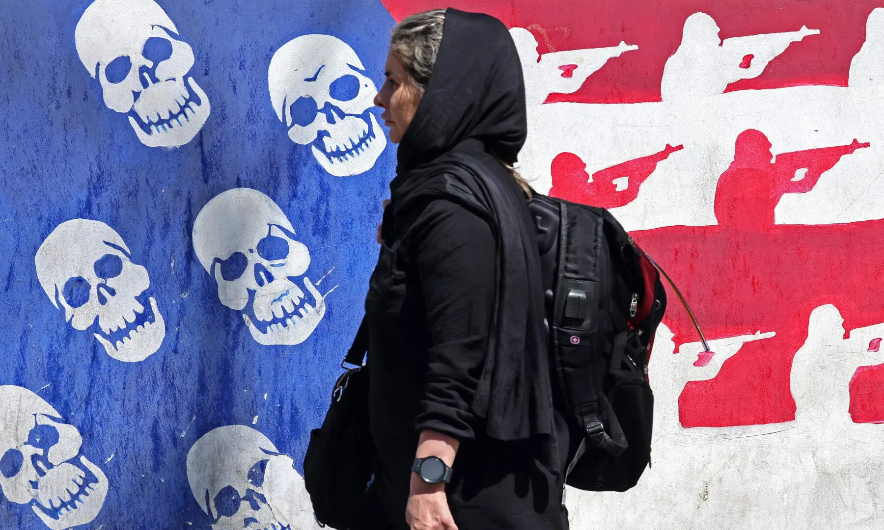 This photo taken on April 11, 2026 shows a woman walking past an anti-US mural near the former US embassy in Tehran.  &mdash; AFP/File