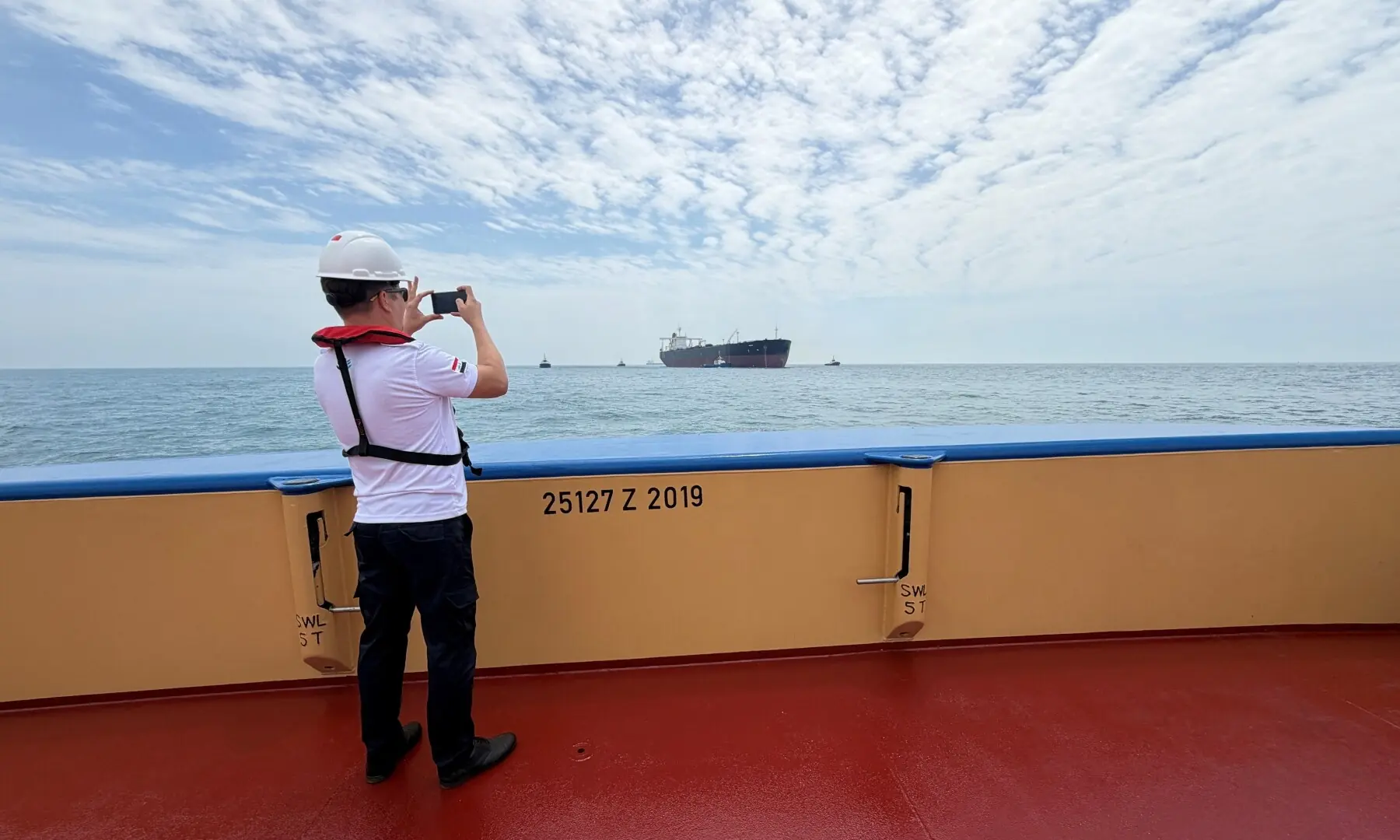 A sailor photographs the oil tanker Helga, moored at one of Iraq&rsquo;s southern offshore oil terminals near Basra on April 24, 2026, as it prepares to load crude oil, becoming the second vessel to arrive since the closure of the Strait of Hormuz. &mdash; Reuters