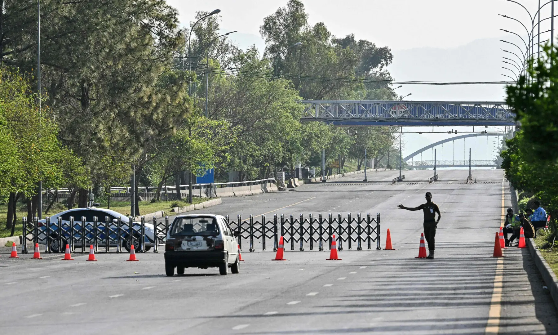 A security personnel diverts traffic at a closed road in the Red Zone area of Islamabad on April 25, 2026. &mdash; AFP