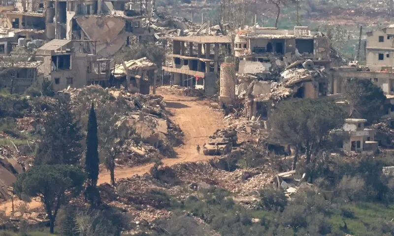 This photograph taken from the northern Israel shows Israeli tanks and military vehicles driving along the road between destroyed houses in southern Lebanon near the border with Israel, on April 25. — AFP This photograph taken from the northern Israel shows Israeli tanks and military vehicles driving along the road between destroyed houses in southern Lebanon near the border with Israel, on April 25. — AFP