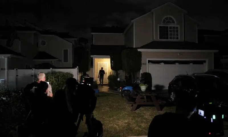 A journalist walks back after knocking on the door of the residence associated with Cole Tomas Allen, the suspect in the shooting incident at the annual White House Correspondents&rsquo; Association dinner in Washington, DC. in Torrance, California, US on April 25. &mdash; Reuters