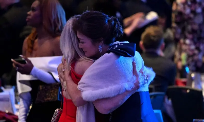 Attendees embrace inside the ballroom after shots were reportedly fired during the White House Correspondents' dinner at the Washington Hilton in Washington, DC, on April 25. &mdash; AFP