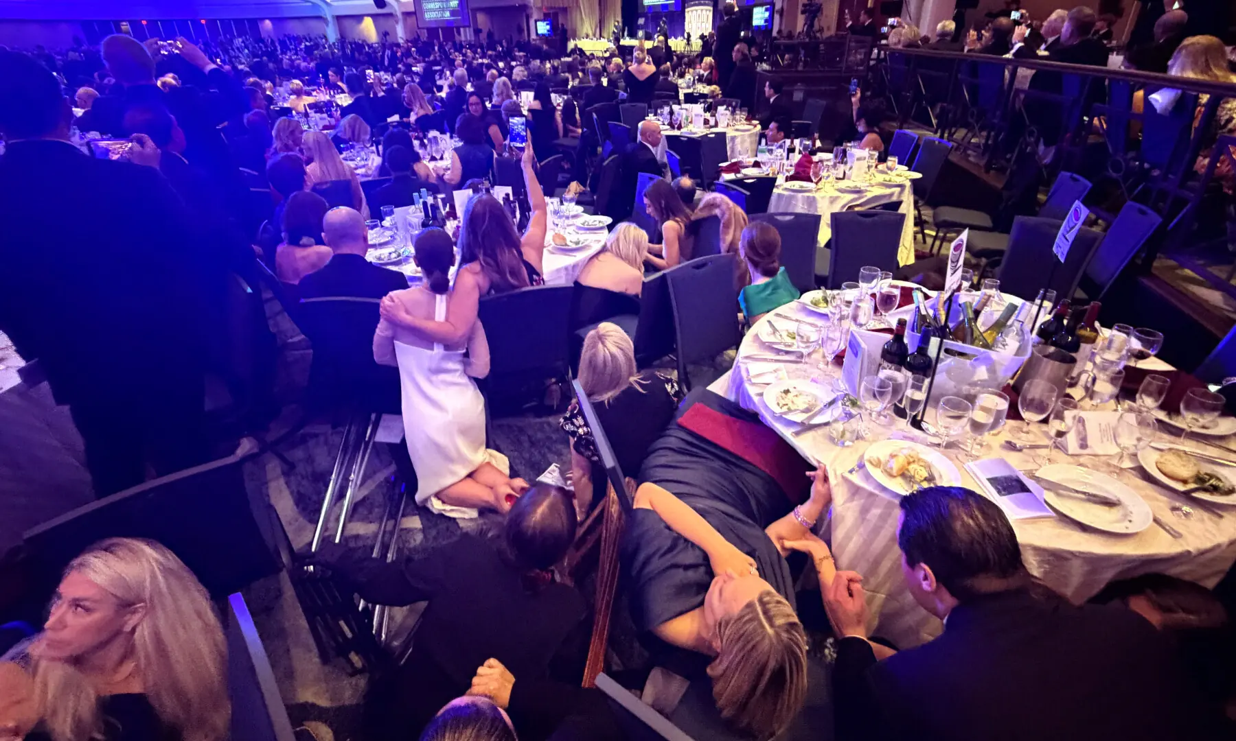 Guests take cover after US President Donald Trump and first lady Melania Trump were rushed out of the White House Correspondents' Association dinner by Secret Service agents after a loud, unidentified noise, in Washington, DC, US on April 25, 2026. &mdash; Reuters