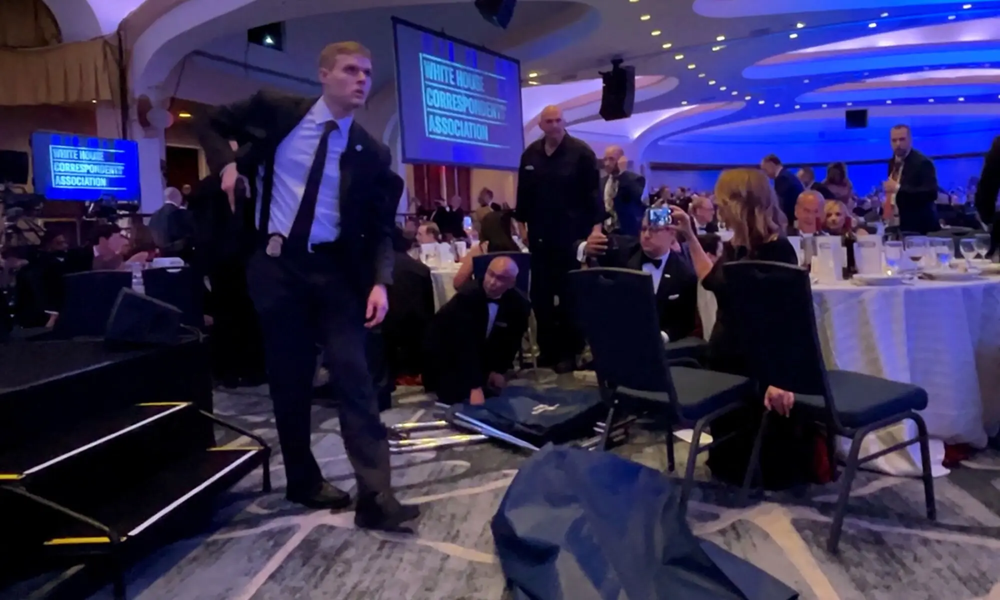 A Secret Service agent unholsters his gun, shortly after US President Donald Trump was evacuated, after a man opened fire with a shotgun on security personnel outside the room during the annual White House Correspondents' Association dinner in Washington, DC. ─ Reuters