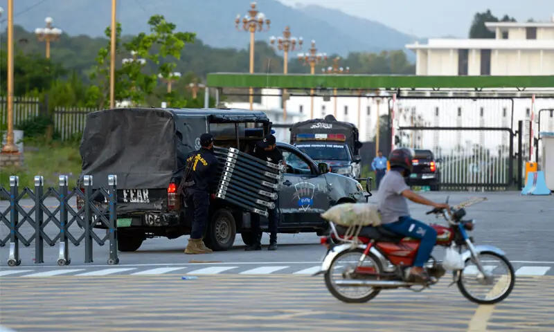 POLICE officials pack up barricades placed at the main entry point of Islamabad&rsquo;s Red Zone. Restrictions on movement in the twin cities eased following the departure of US and Iranian officials.&mdash;Mohammad Asim