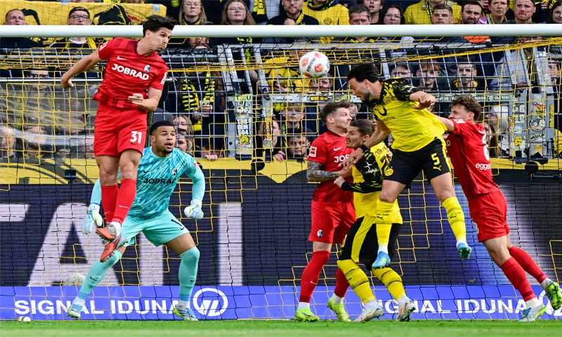 DORTMUND: Ramy Bensebaini (second R) of Borussia Dortmund heads to score during the Bundesliga match against Freiburg.&mdash;AFP