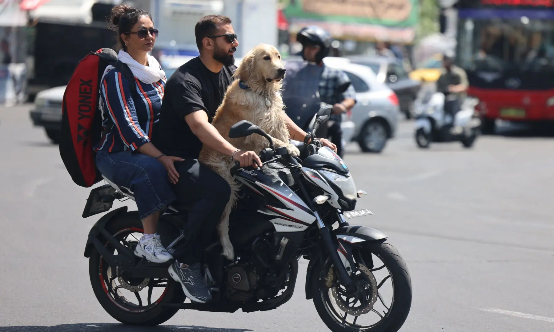 A couple with a dog ride a motorbike through Tehran&rsquo;s Enqelab Square in  Iran on April 28, 2026. &mdash; AFP