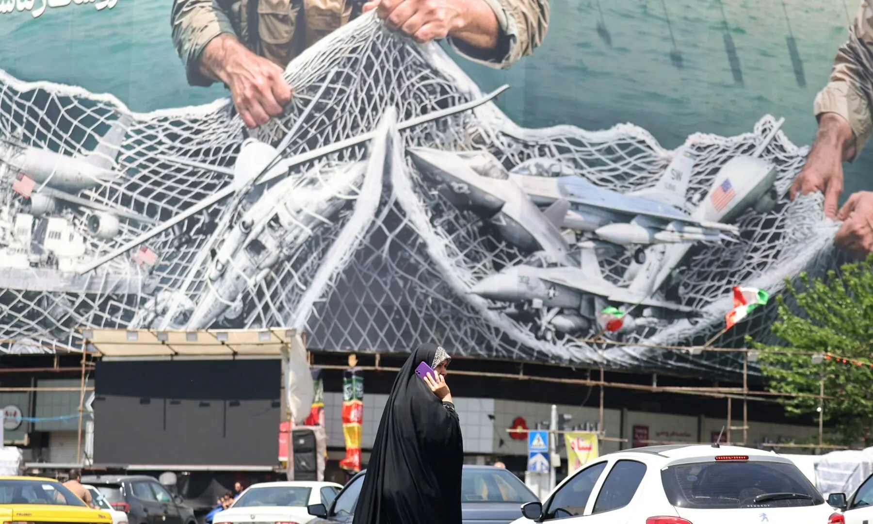 A woman walks past a giant billboard reading &lsquo;the Strait of Hormuz remains closed&rsquo; at Enghelab Square in Tehran on April 28, 2026. &mdash; AFP