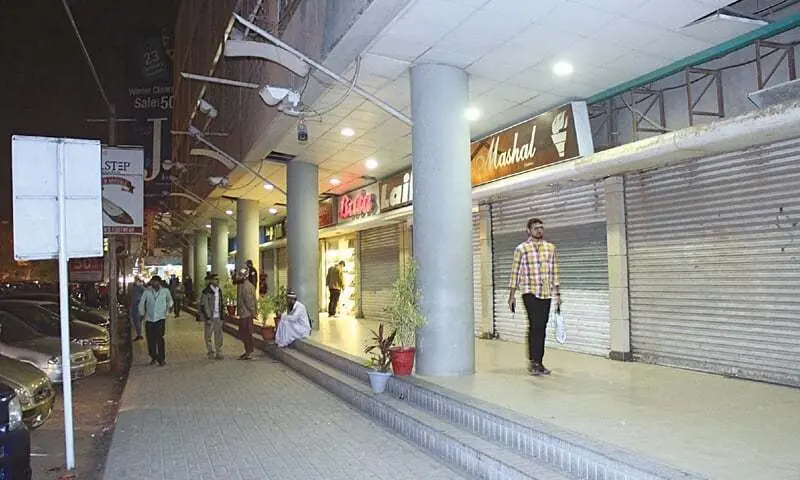 A file photo of people walking past closed shops at night.&mdash;PPI/File