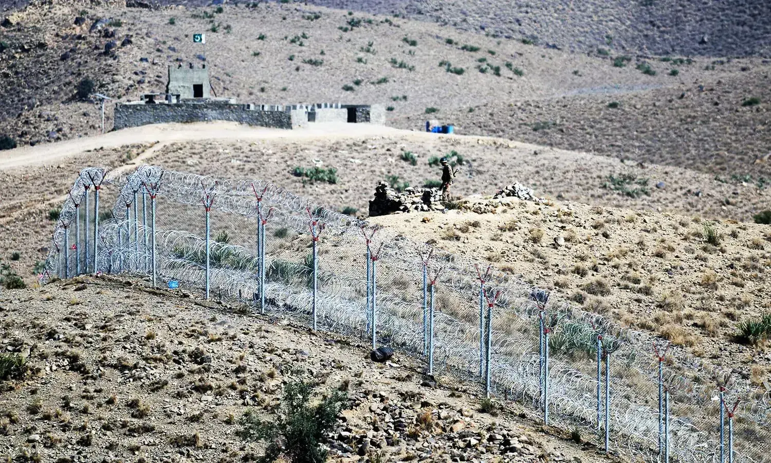 A Pakistani soldier keeps vigil beside a newly fenced border fencing along Afghan border at Kitton Orchard Post in Pakistan's North Waziristan tribal agency on October 18, 2017. &mdash; AFP/ File