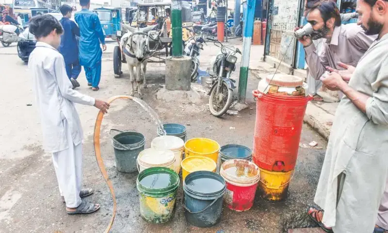 A boy fills buckets with water in a Lyari area.&mdash;Fahim Siddiqi / White Star
