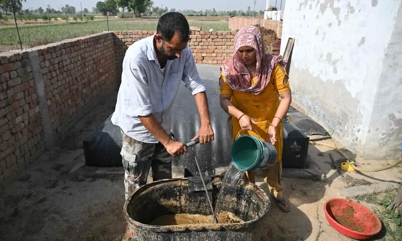 This photograph taken on April 24, 2026 shows residents pouring cow dung into their biogas plant at a village in Uttar Pradesh&rsquo;s Bulandshahr district. &mdash;AFP