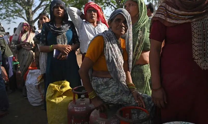 This photograph taken on April 24, 2026 shows people waiting with empty LPG (liquefied petroleum gas) cylinders for refilling, in a village on the outskirts of Uttar Pradesh&rsquo;s Jewar district. &mdash;AFP
