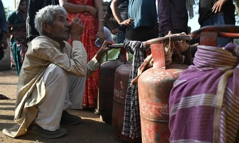This photograph taken on April 24, 2026 shows people waiting with empty LPG (liquefied petroleum gas) cylinders for refilling, in a village on the outskirts of Uttar Pradesh&rsquo;s Jewar district. &mdash;AFP