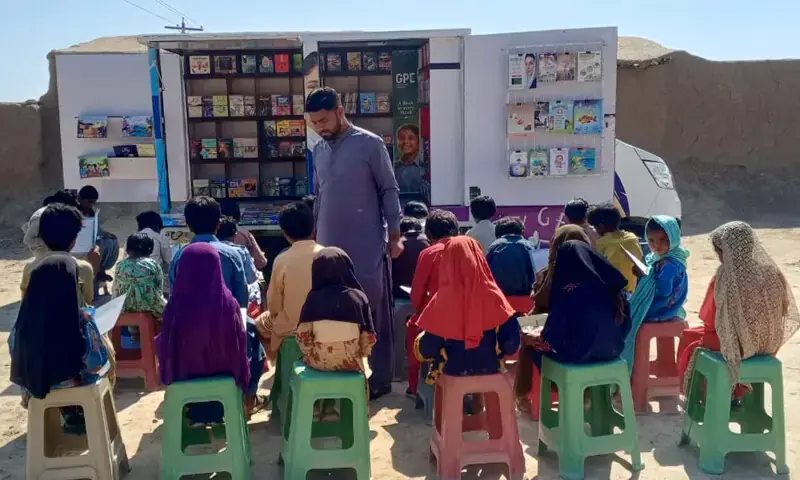 Children read at a book van pop-up, conducted by the provincial education department with support from Unicef.&mdash;Dawn/File