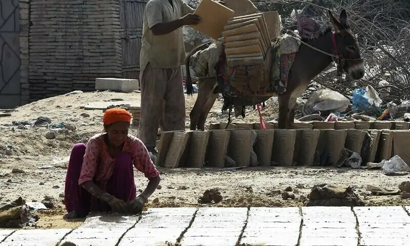 Labourers make bricks at a factory in Karachi. -AFP/File
