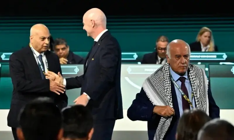 FIFA President Gianni Infantino shakes hands with Moshe Zuares, president of the Israeli football federation, as Jibril Rajoub, president of the Palestine Football Association. leaves the stage during the congress. &mdash;Reuters