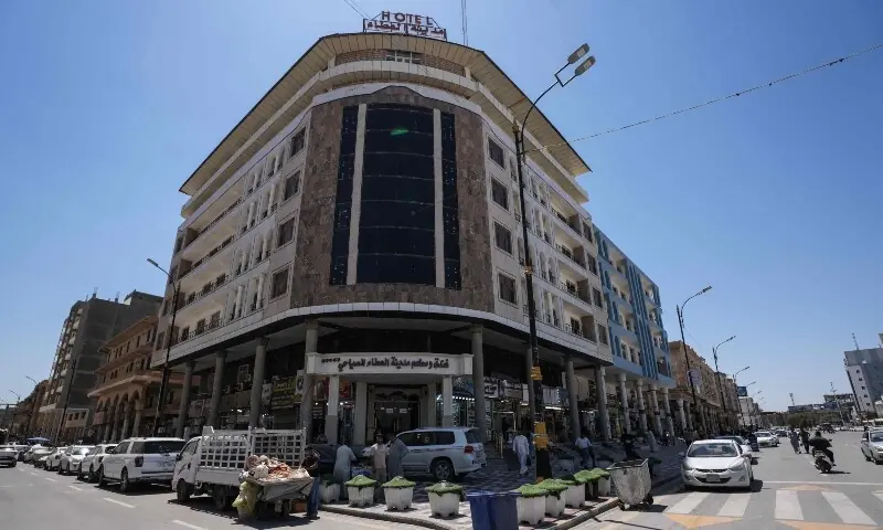 People stand outside a hotel in Najaf on April 22. &mdash; AFP