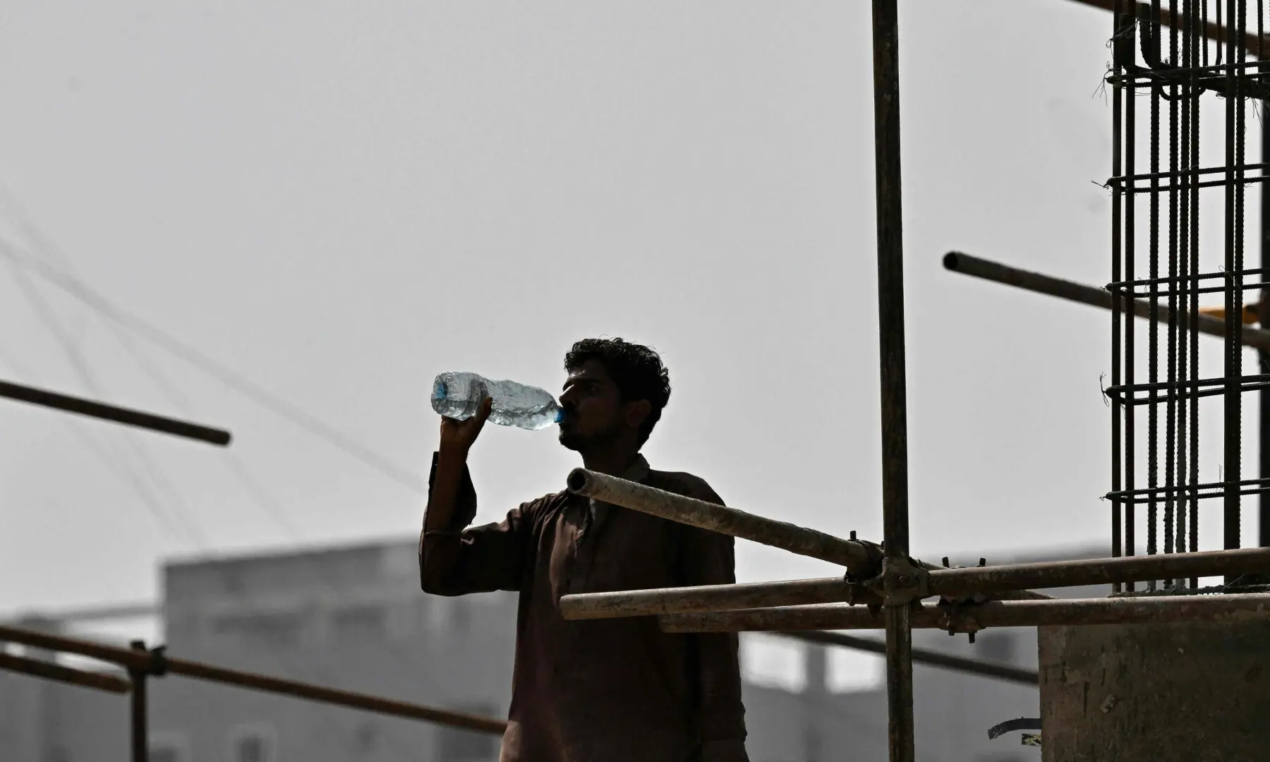 A worker drinks water at a construction site on a hot summer day in Karachi on May 5, 2026. — AFP A worker drinks water at a construction site on a hot summer day in Karachi on May 5, 2026. — AFP