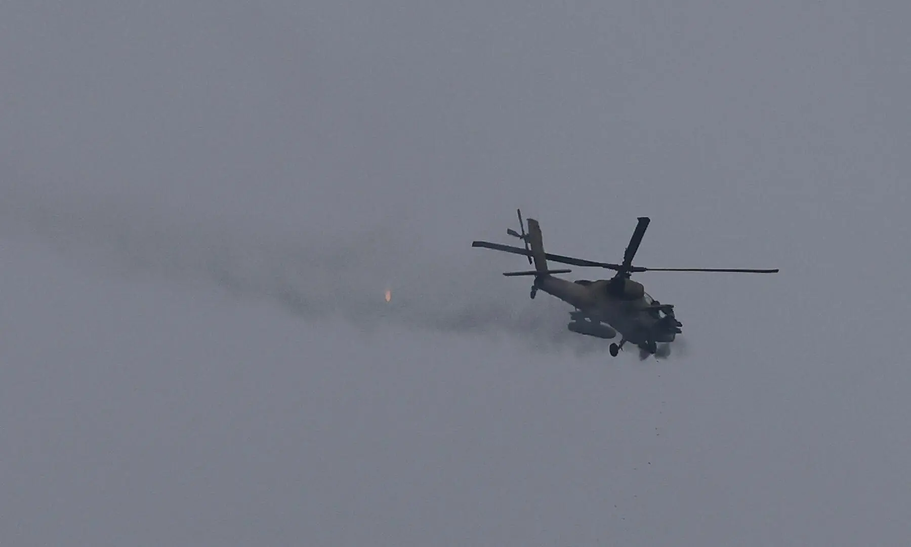 An Israeli helicopter fires its cannon, as seen from near the Israel-Lebanon border, on May 5, 2026. &mdash; Reuters