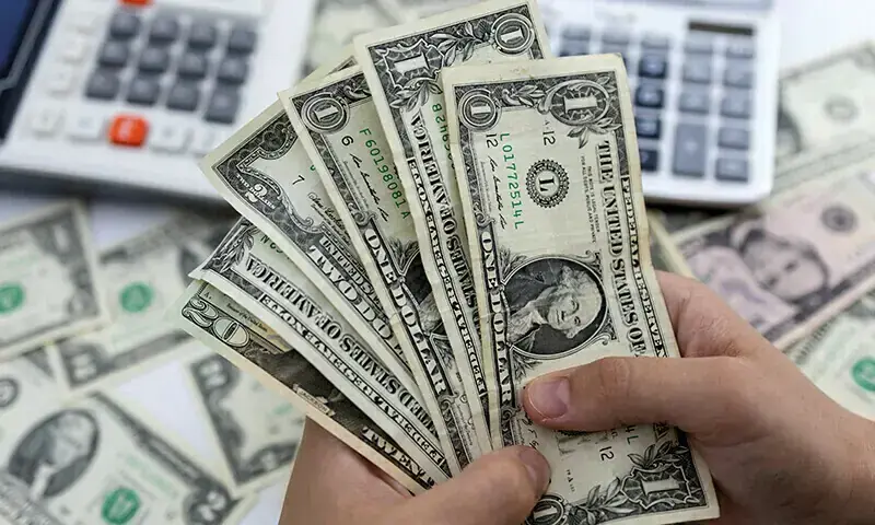 A person holds US dollar banknotes in this file photo taken May 30, 2022.--REUTERS/Dado Ruvic/Illustration/File Photo
