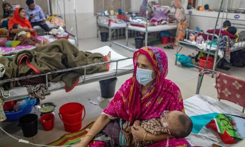 A woman holds a child diagnosed with measles inside a paediatric ward at the Bangladesh Shishu Hospital and Institute in Dhaka on May 6. &mdash; AFP