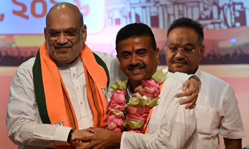 India's Home Minister Amit Shah (L) greets Bharatiya Janata Party (BJP) leader and newly selected Chief Minister of West Bengal Suvendu Adhikari (C) during a party meeting in Kolkata on May 8, 2026. &mdash; AFP