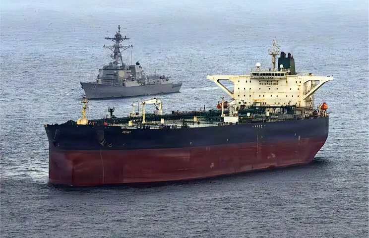 THIS US Navy handout photo shows the Arleigh Burke-class guided-missile destroyer USS Rafael Peralta (left) implementing a maritime blockade against the Iran-flagged crude oil tanker vessel Herby, as it was attempting to sail towards an Iranian port.&mdash;AFP